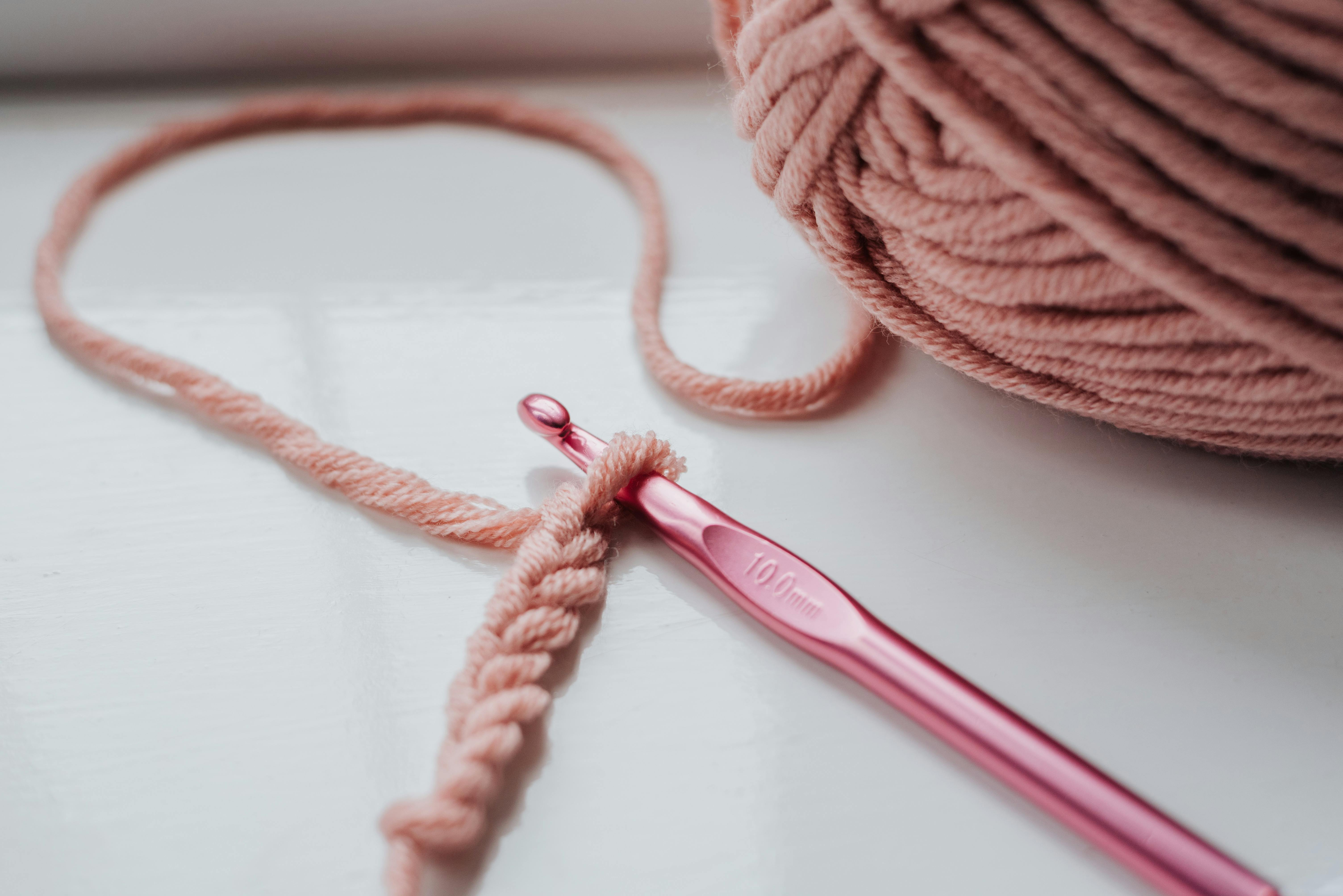 a chain of pink yarn on a crochet hook